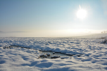 Landscape with a lot of snow, fields ,frozen spots, fog and sun © Claudia Evans 