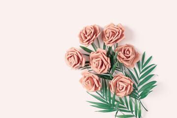 Die Blumenkomposition besteht aus Rosen und grünen Blättern auf einem beigen Pastellhintergrund. Blumenlayout für Frauentag, Muttertag, Valentinstag, Grußkarte. Flach liegen. Ansicht von oben. Platz kopieren. © happy_e