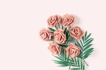 Die Blumenkomposition besteht aus Rosen und grünen Blättern auf einem beigen Pastellhintergrund. Blumenlayout für Frauentag, Muttertag, Valentinstag, Grußkarte. Flach liegen. Ansicht von oben. Platz kopieren. © happy_e