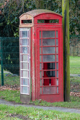 Old broken and smashed up red telephone box