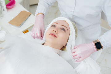A young girl in a cosmetology office is undergoing facial skin rejuvenation procedures. Cosmetology.