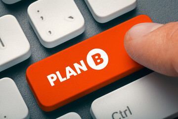 Close up finger of businessman pressing orange computer key with Plan B word. Changing business...