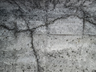 Cracks in a large, solid concrete slab. The effect of the destruction of a new building. Gray texture with damaged surface.