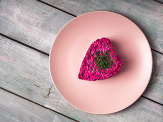 Beetroot salad in the shape of a heart on a pink plate