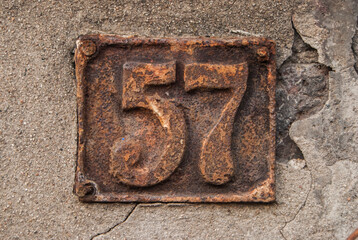 Old retro weathered cast iron plate with number 57 closeup