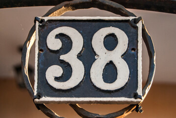 Old retro weathered cast iron plate with number 38 closeup