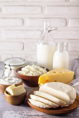 Set of different dairy products (milk, sour cream, cottage cheese, yogurt and butter) on a light stone countertop. Copy space.