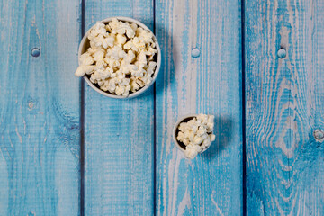 Popcorn bowls on blue wooden background