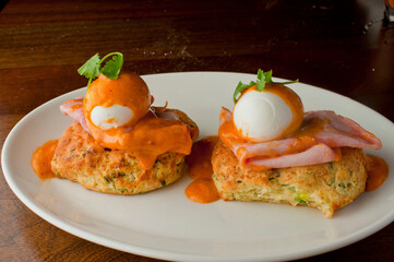 Eggs Benedict. Traditional classical American diner or French Bistro brunch item. Homemade Hollandaise sauce drizzled over a poached egg, country ham on top of a toasted English muffin.  