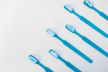 Plastic blue toothbrushes with toothpaste isolated on a white background. Flat lay style. High quality photo