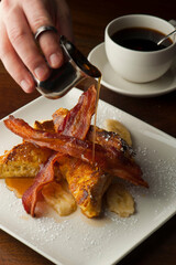 French toast. Brioche bread soaked in egg, milk and fried in butter and topper with apples, cinnamon, powdered sugar and syrup. Traditional classical American diner or French Bistro brunch entree.