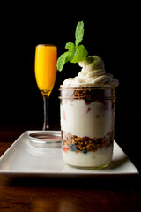 Parfait. Traditional classic breakfast or brunch favorite. Greek yogurt hand rolled granola with dried cranberries and almonds, layered in a jar and served with a classic brunch cocktail a mimosa. 