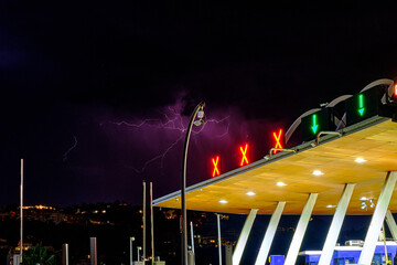 Lightning storm over the city in purple light on a tollbooth