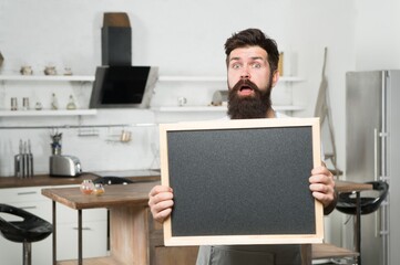 mature handsome man barista with empty blackboard, copy space, ad