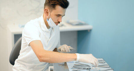 Dental technician working with a model of teeth trying on a brace system for orthodontic treatment...