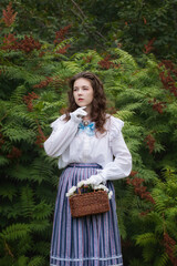 Girl in vintage clothes with a wicker bag