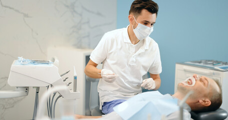 Dentist adjusting dental braces during orthodontic treatment for the young male patient. 4k video screenshot, please use in small size