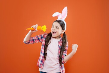 happy child girl in easter bunny ears having fun hold carrot, happy easter