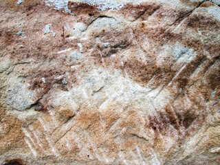 Primitive old rock. Brown textured background with warm colors. Scratches and cracks in hard mineral.