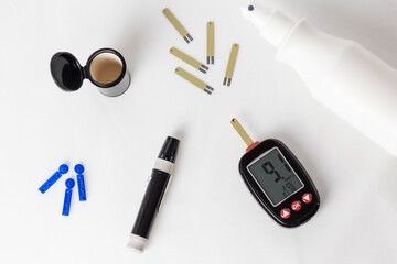 Needs for measuring glycemia in diabetics. Glucometer, strips, blue needles, white disinfectant and black lancet case.