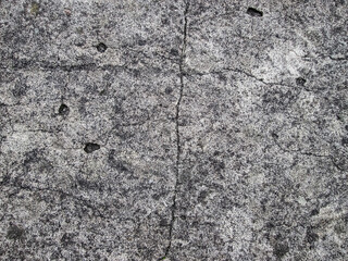 Cracks in the gray concrete slab. Stock texture with destruction.