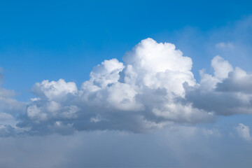 Naklejka na ściany i meble Fluffy clouds in the cloudy sky.