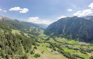 Naklejka na ściany i meble Aerial drone shot of Helligenblutt village in Grossglockner mountain valley in Austria