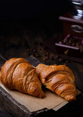 croissants on a wooden board on a brown background