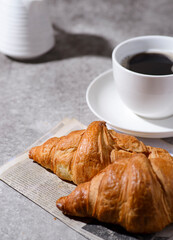 croissants on a gray background and a cup of coffee