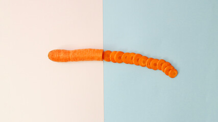 Organic carrot cut in half on white and bright blue background. MInimalistic concept for  fresh healthy  food.