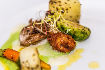 Quail thigh with roasted vegetables. The food in the restaurant. Food styling and restaurant meal serving.