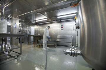 Wide angle background image of female worker washing equipment at clean food production factory, copy space