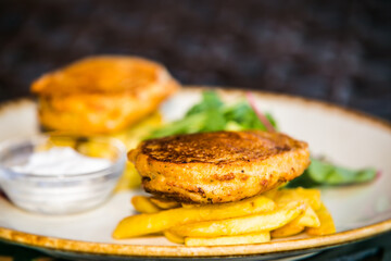 Fried cheese with french fries with side dishes. The food in the restaurant. Food styling and restaurant meal serving.