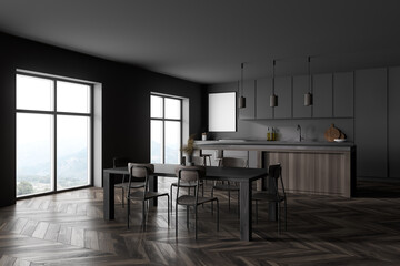 Modern kitchen interior with dark gray walls, a wooden parquet floor and gray countertops. A long table with chairs near it. mock up poster on wall.