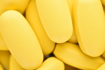 Several oval yellow pills, close-up.