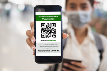 Traveler shows health passport of vaccination certification on phone at airport, to certicy that have been vaccinated of coronavirus covid-19