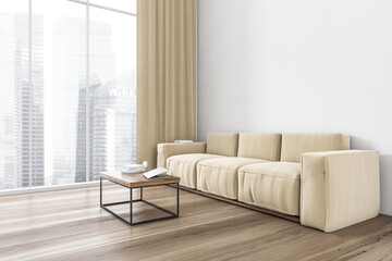 Beige sofa in living room near window and white wall with coffee table