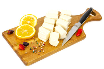 Slices of white fresh feta on wooden cutting board