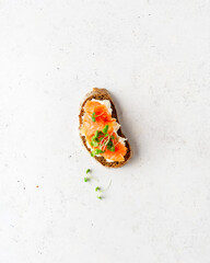 Toasted bread with ricotta (cream cheese), smoked salmon and micro greens on white stone background. Health care, super food concept. Top view. Copy space.