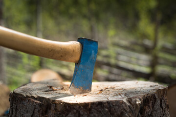 Old axe in the top of a chopping block