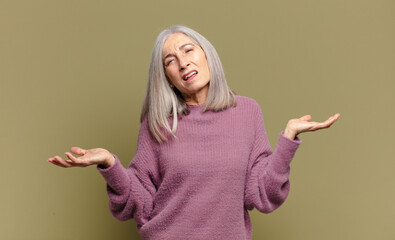 senior woman looking puzzled, confused and stressed, wondering between different options, feeling...