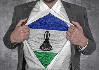 Business man show t-shirt flag of Lesotho rips open his shirt