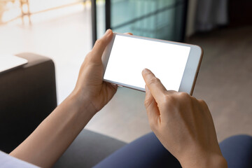 Close-up woman of hand held with smart phone white screen on sofa in the living room. Concept of...