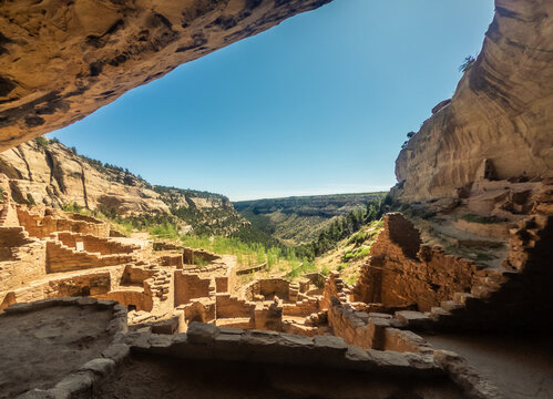 View out from rock overhang to canyon and ruins of old clay town in mesa verde national park in america