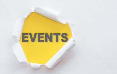 Top view of white torn paper and the text EVENTS on a yellow background.