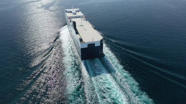 Aerial drone video of RoRo (Roll on-off) automobile - car transportation vessel cruising Saronic gulf deep blue sea