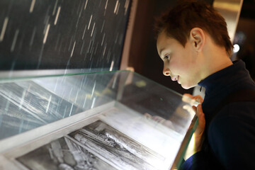 Child examines photographs in museum