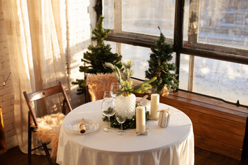 A festive day, a set table with New Year's decor. Candles and a cozy atmosphere. Christmas time. 