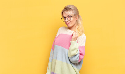 blonde woman looking arrogant, successful, positive and proud, pointing to self