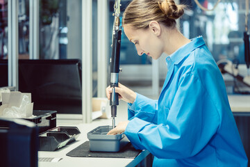 Woman in factory assembling a product